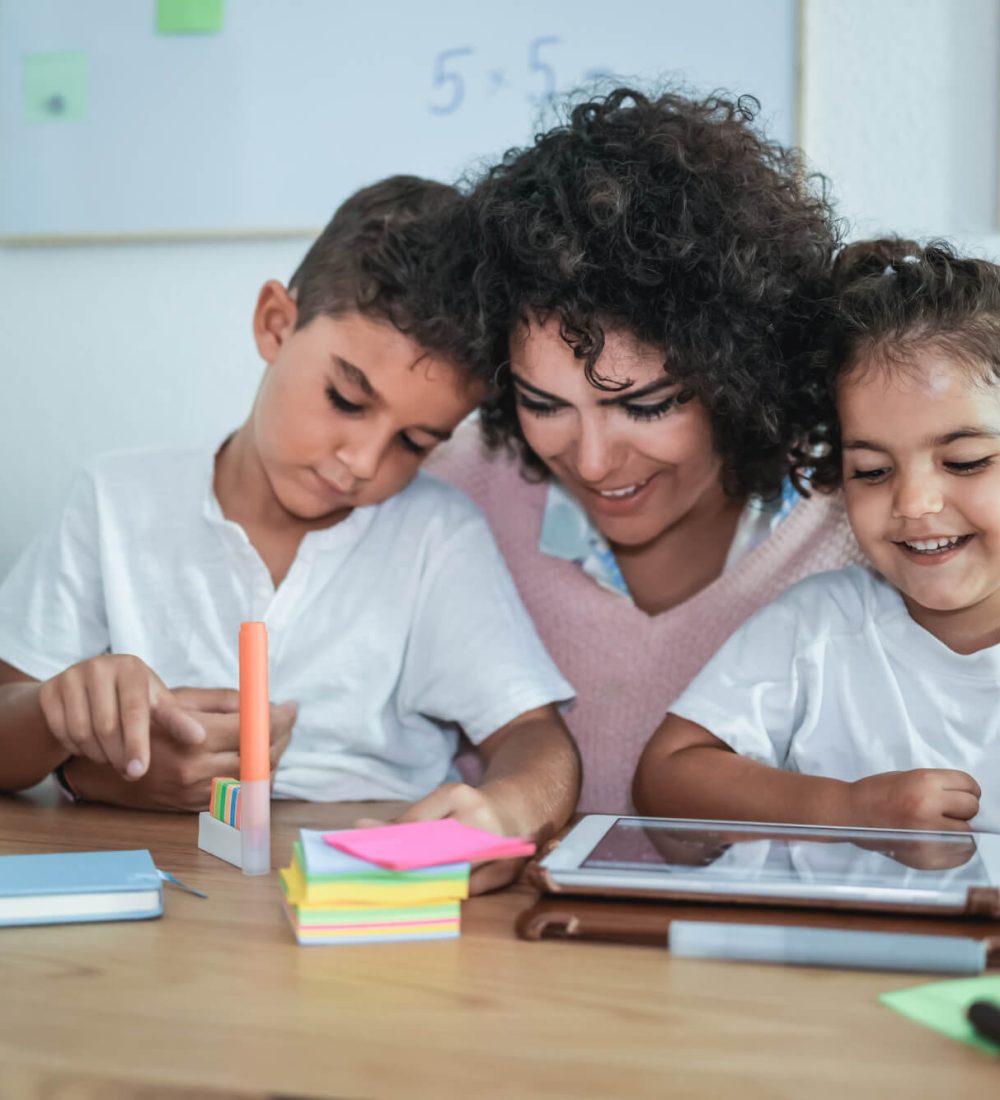 teacher-using-tablet-with-children-in-kindergarten-school-focus-on-girl-face.jpg